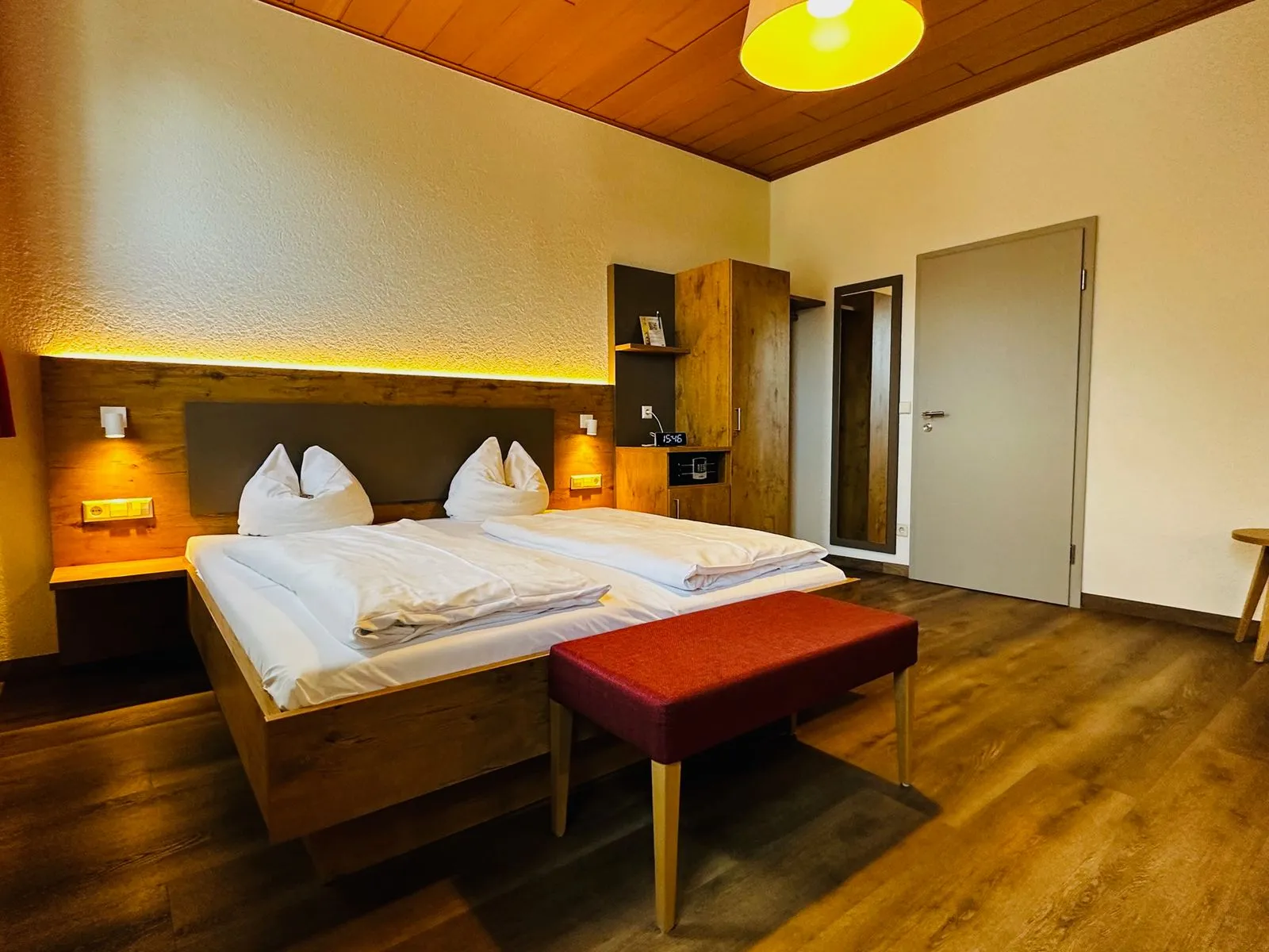Doppelzimmer mit Holzdecke und roter Bank